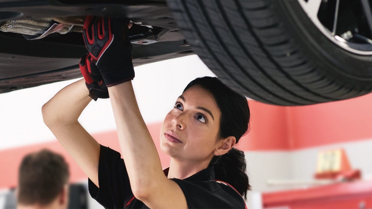 Técnica de Toyotoshi realizando el mantenimiento de un vehículo